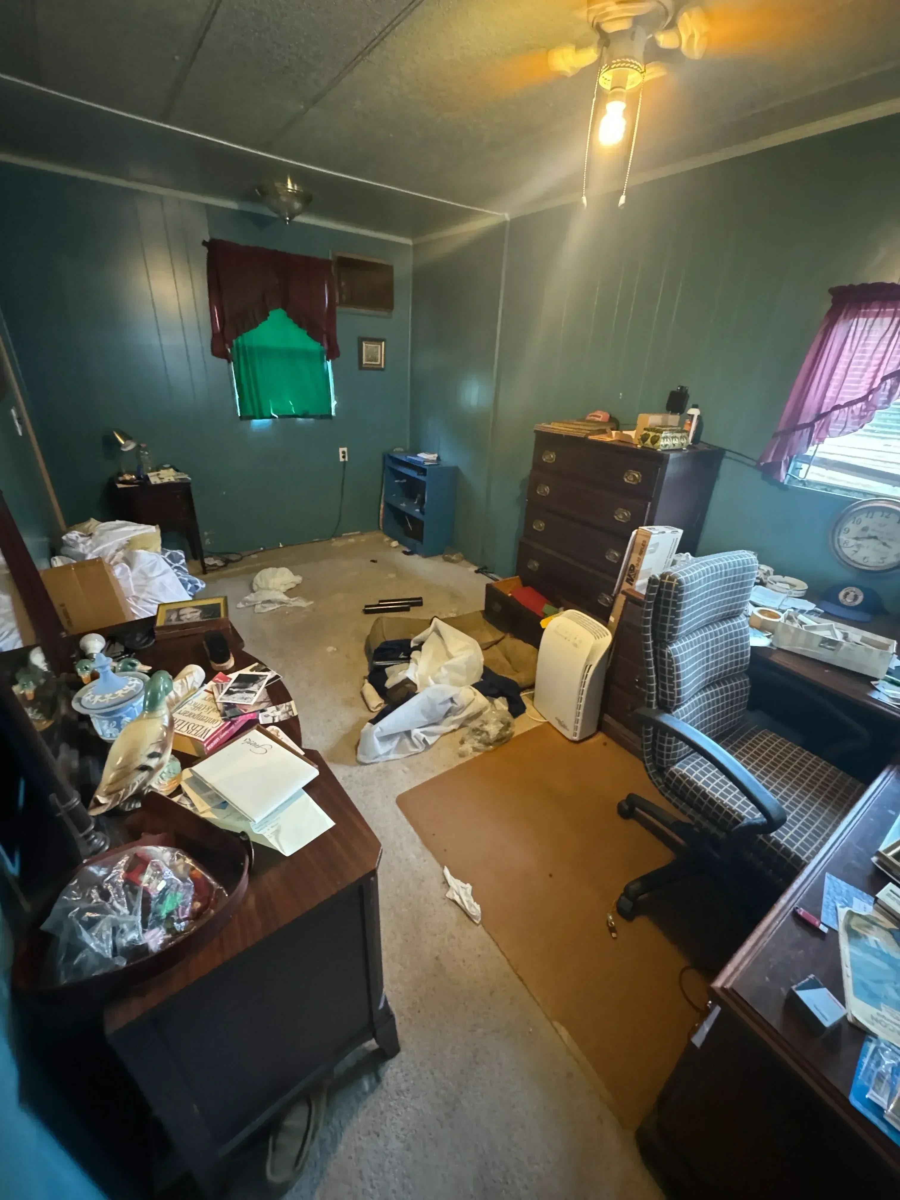 Interior room with accumulated debris, furniture, and materials staged for removal and hauling