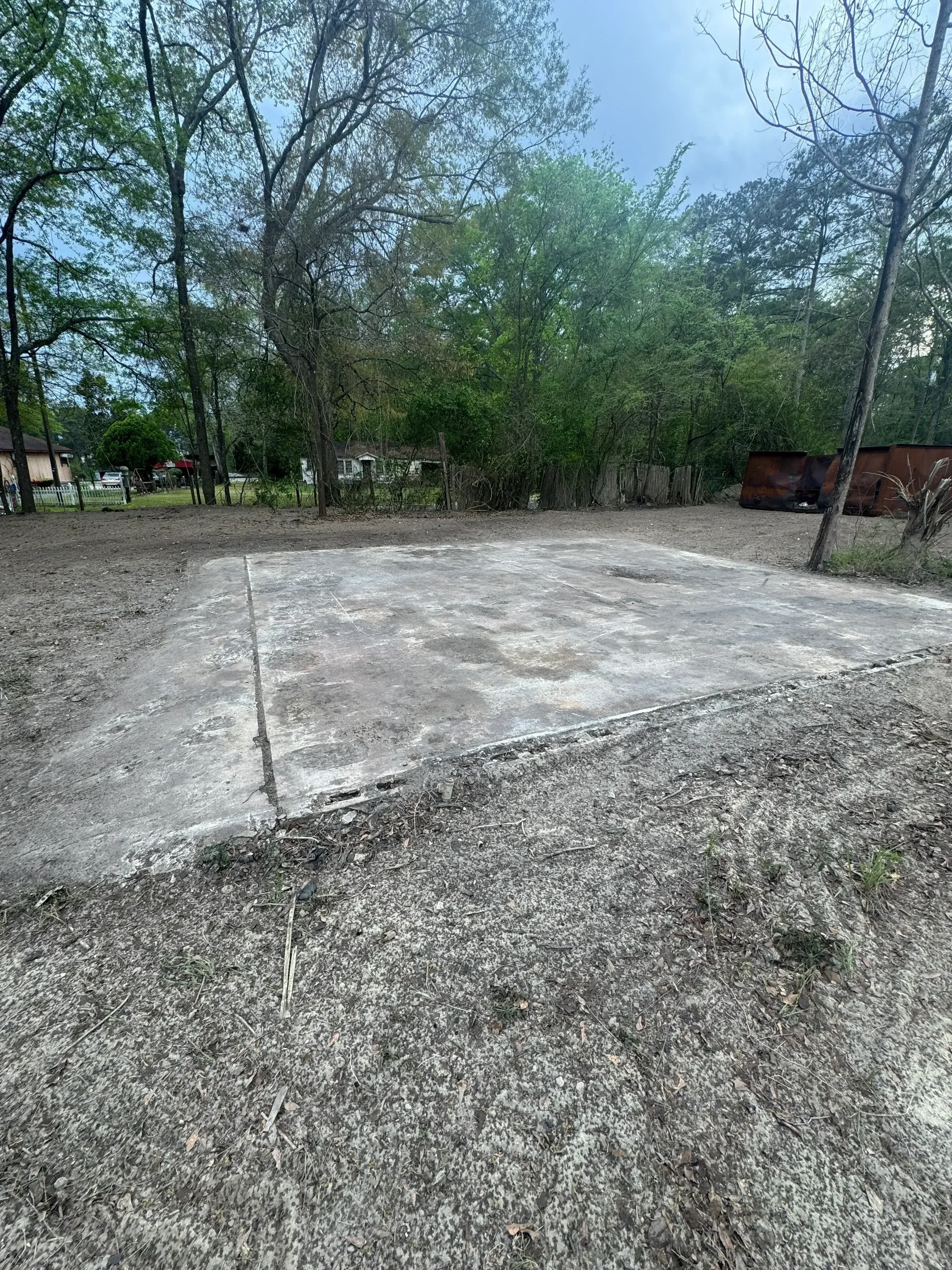 Broken concrete driveway with deep cracks and uneven surface ready for demolition