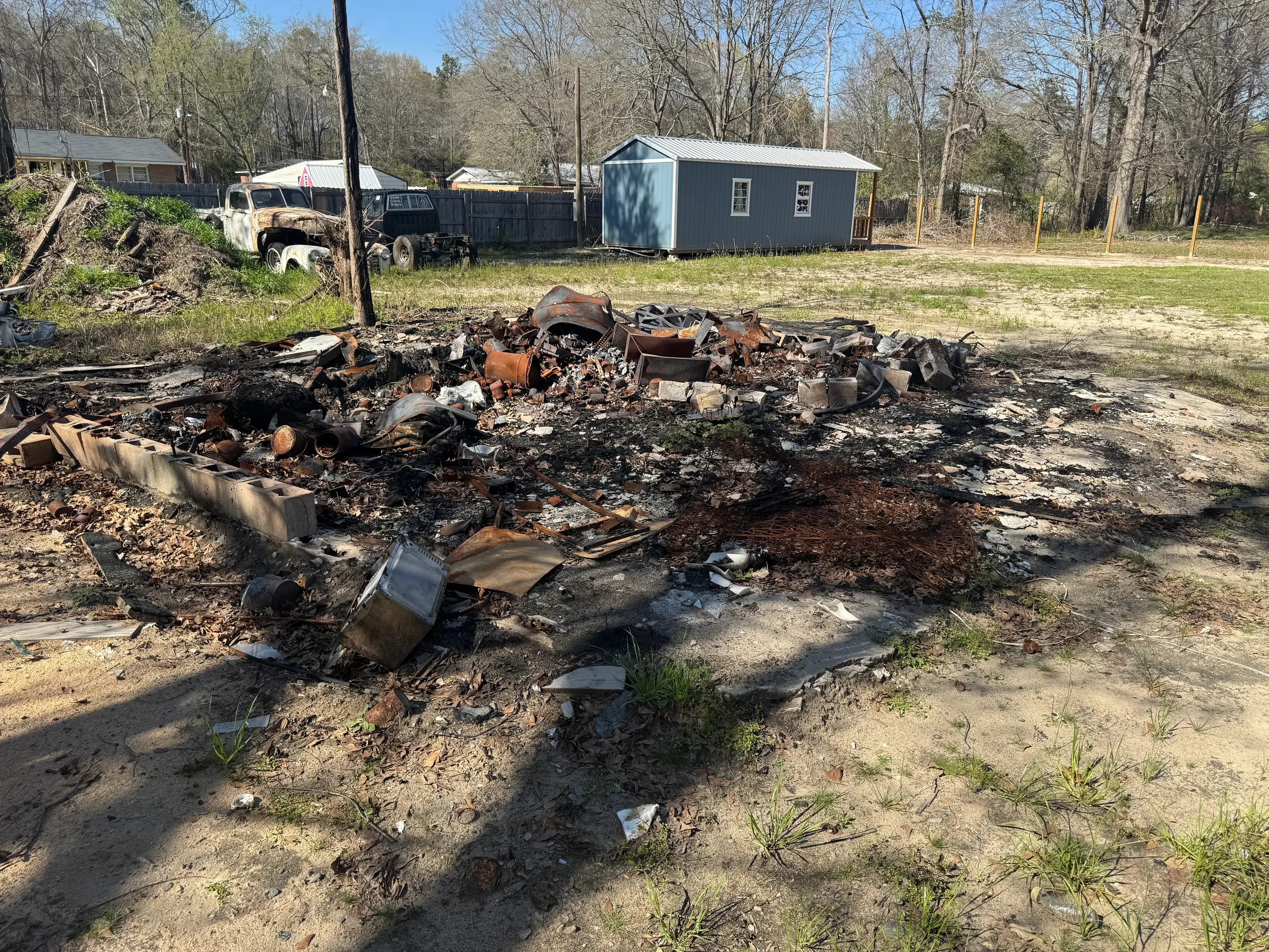 Scrap metal pile with rusted car parts, metal debris, and automotive waste cleared from property