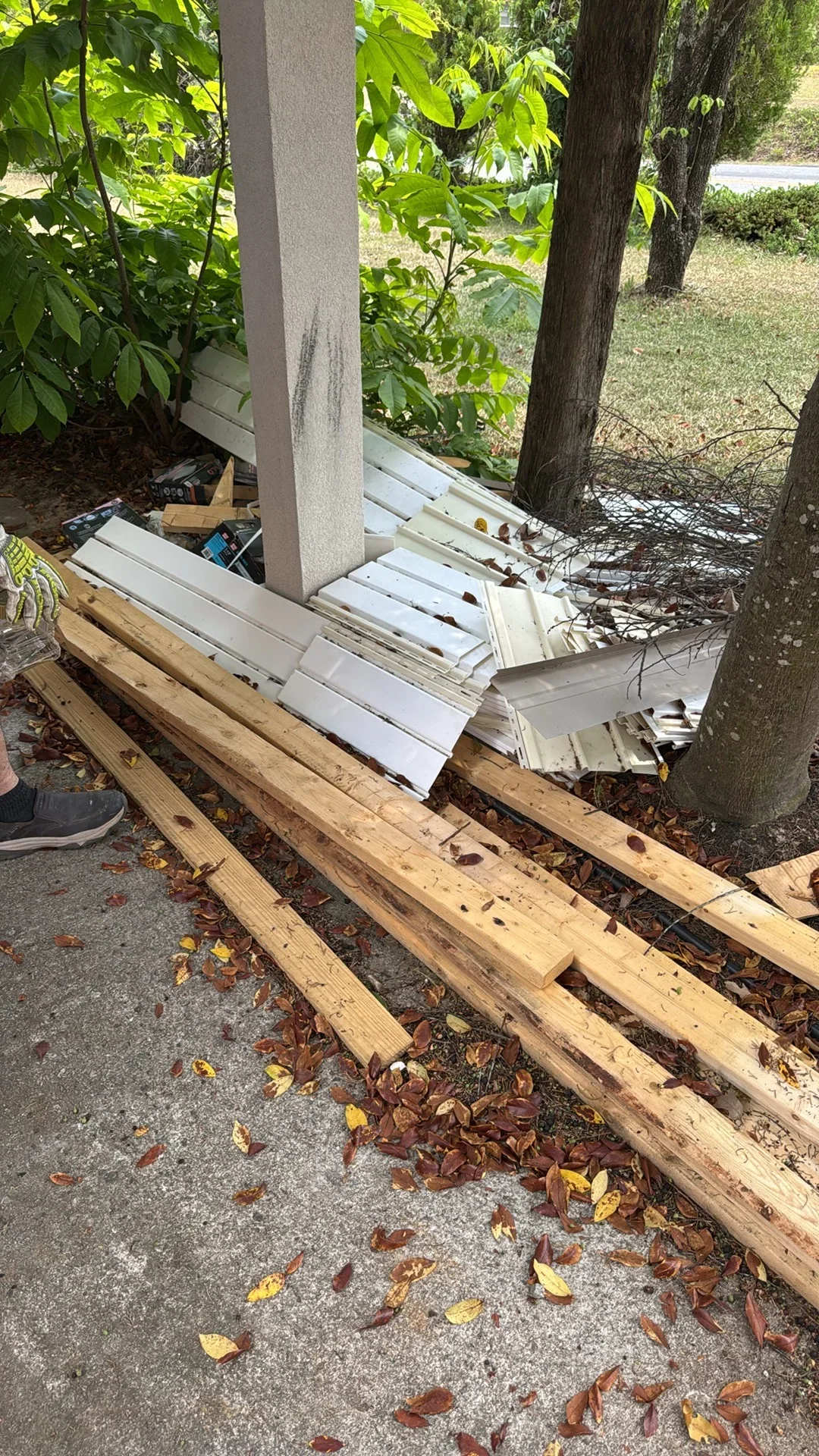 Stacked white vinyl soffit and fascia trim materials on wooden pallets ready for removal