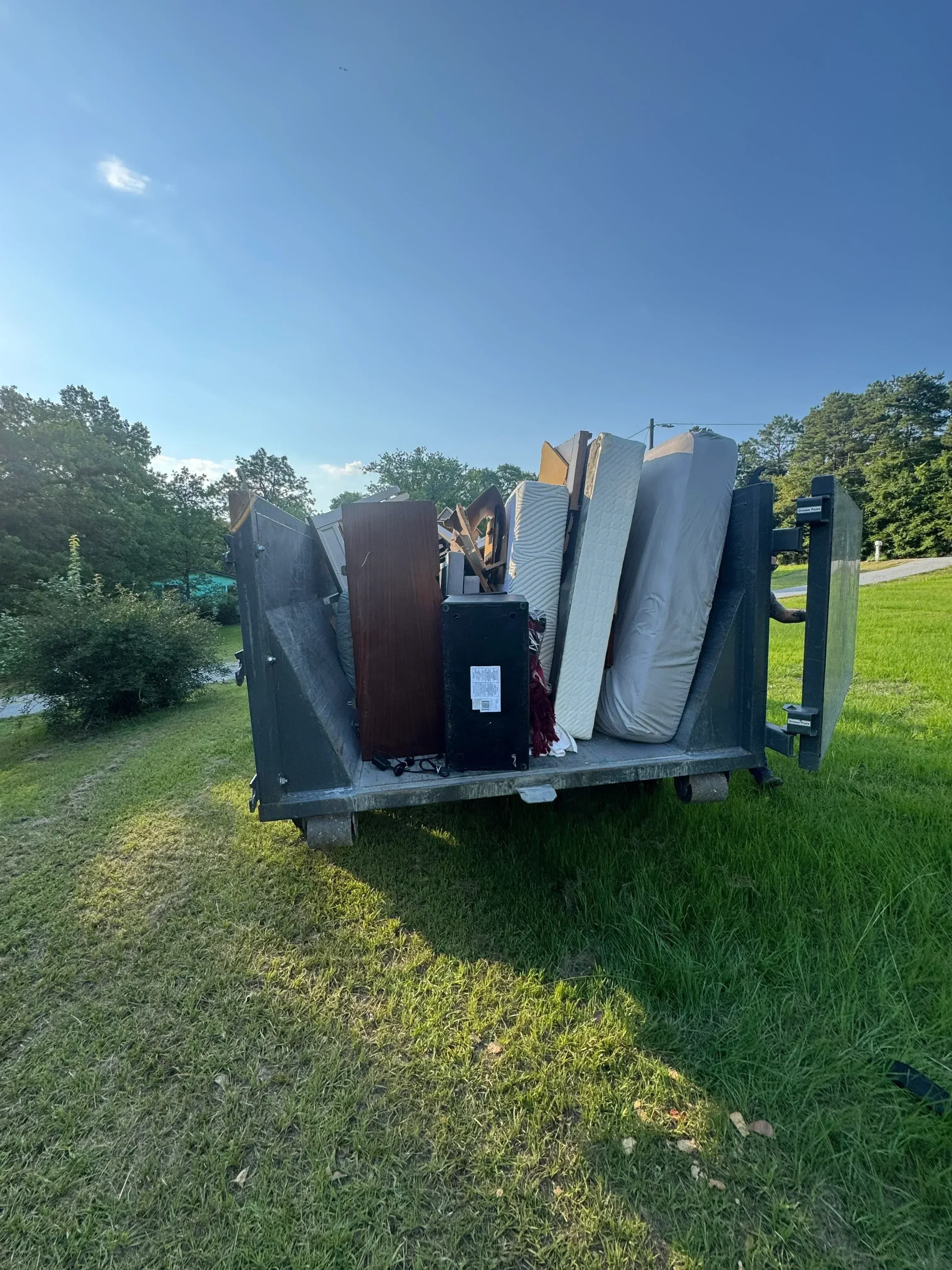 Loaded dump trailer with insulation, drywall, and construction debris ready for removal