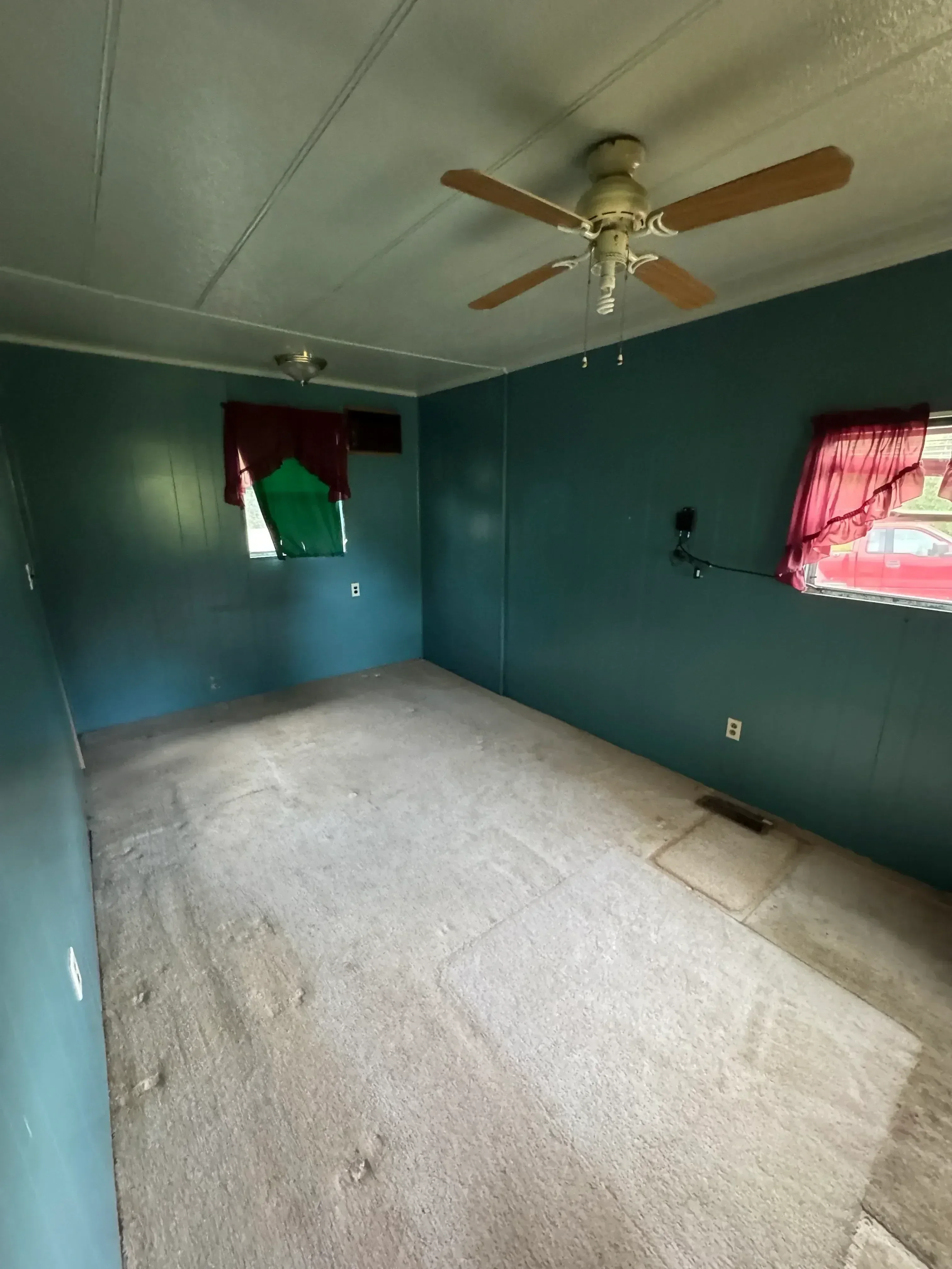 Interior demolition showing exposed drywall removal, concrete flooring, and stripped ceiling framing