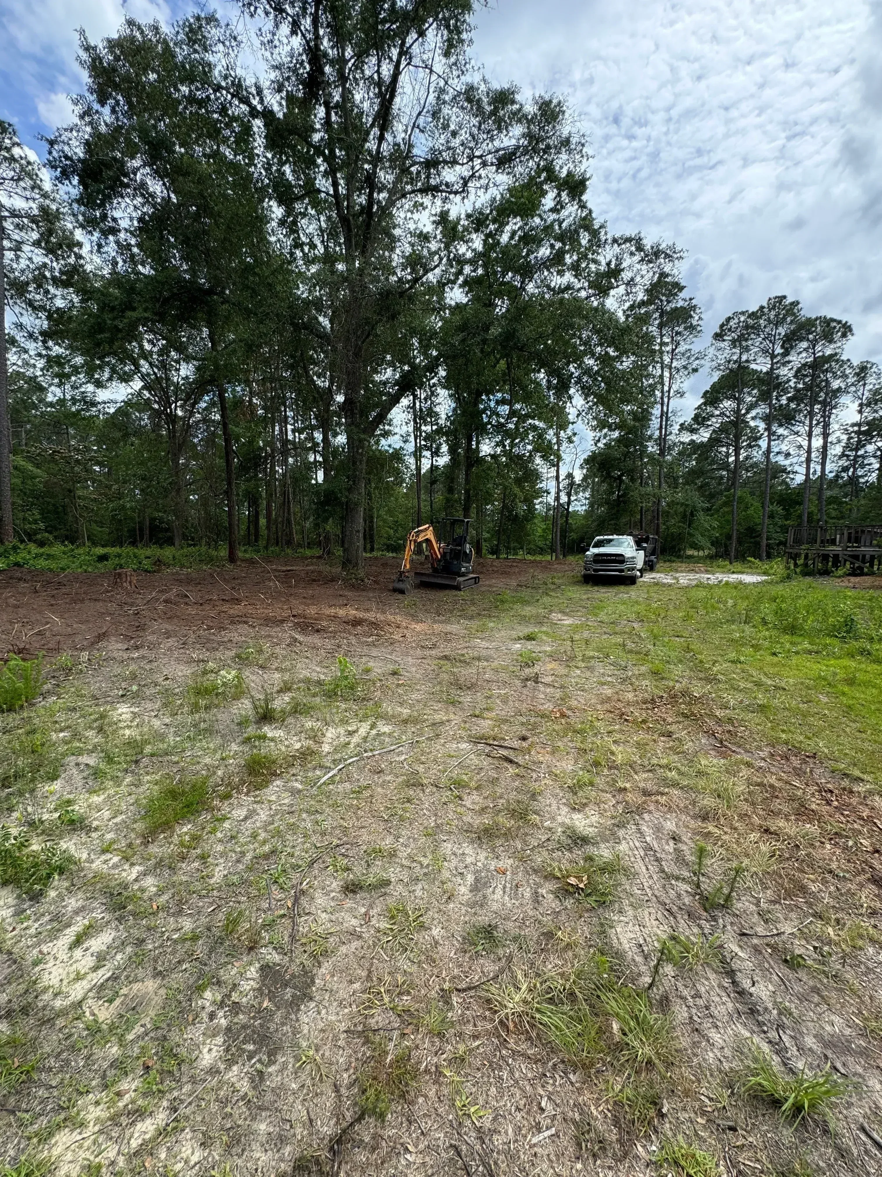 Concrete driveway demolition with broken sections and debris removal in progress