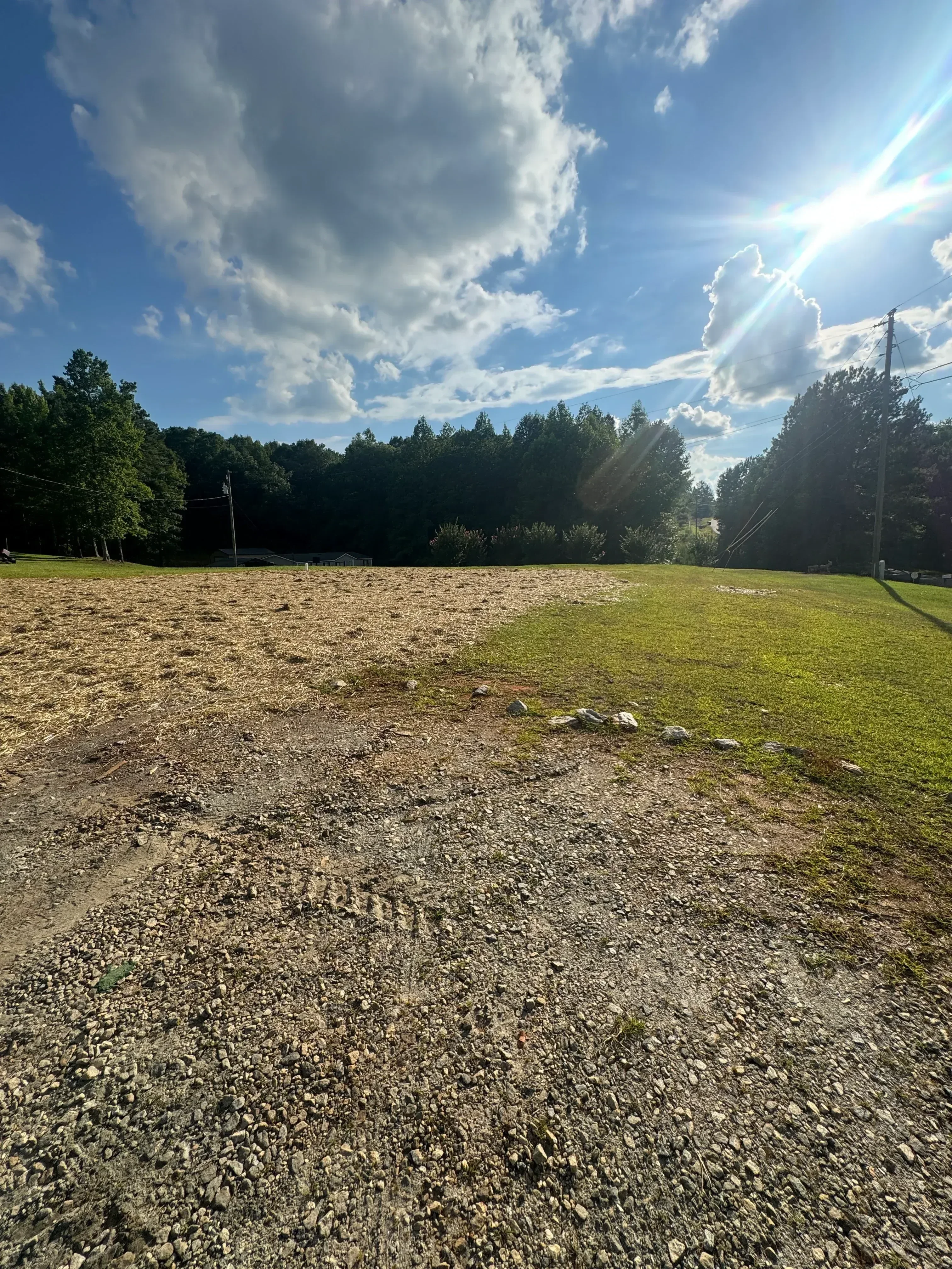 Graded gravel driveway with crushed stone base and sloped site preparation