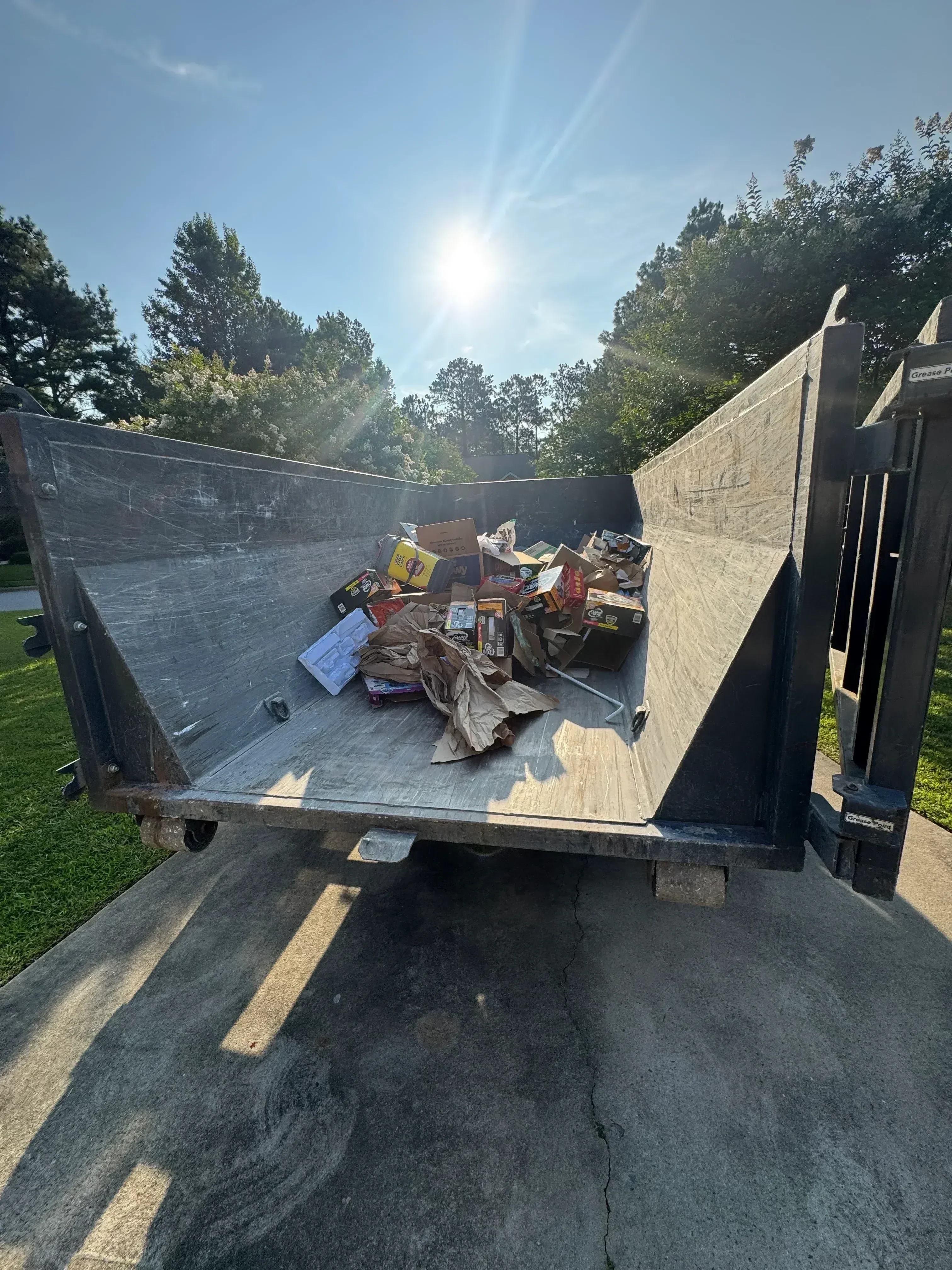 Loaded truck bed with sorted household items, furniture, and boxes ready for hauling